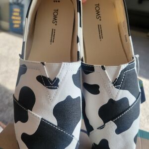 TOMS Black and White Cow Print Slip-On Shoes
